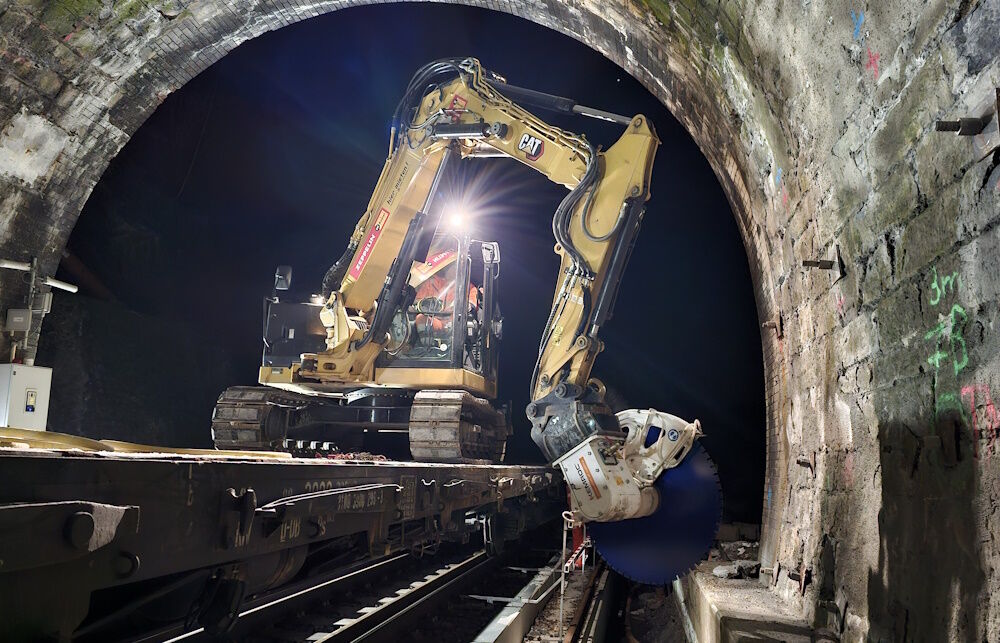 Ein Acht-Tonnen-Bagger mit einer Diamantsäge KDS 30 hat bei der Erneuerung des Elleringhauser Tunnels Beton-Kabelkanäle am Tunnelfuß zerschnitten, um den Einbau einer neue Innenschale zu ermöglichen. (Bild: Kemroc)